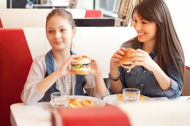 istock A mother having a burger in a diner with her daughter  469764298
