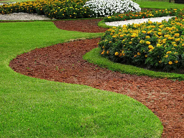 Photo of Park design stone pathways in grass with flower beds