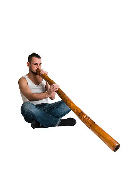 young caucasian man play music on his didgeridoo (Australian national musical instrument)