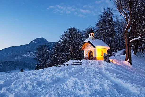 Chapel at Lockstein at sunset with Christmas tree in front of mountain, Berchtesgaden, Germany.