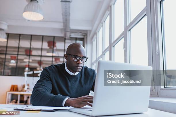 Businessman Working On Laptop In Office Stock Photo - Download Image Now - Men, African Ethnicity, Research