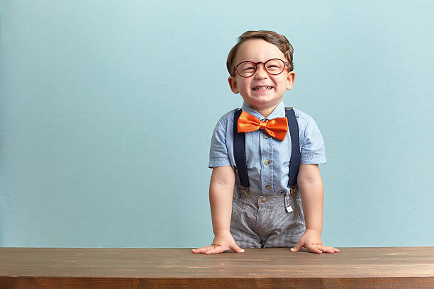 istock Smiling little boy sporting an orange bow tie and glasses 469772394