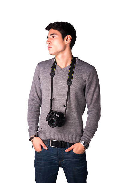 Handsome young man with professional photo camera hanging from his neck, isolated on white