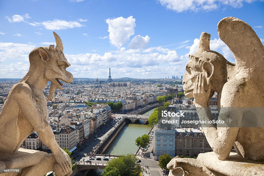 Paris skyline framed by two gargoyles of Notre Dame Famous Chimeras overlooking the skyline of Paris at a summer day Gargoyle Stock Photo
