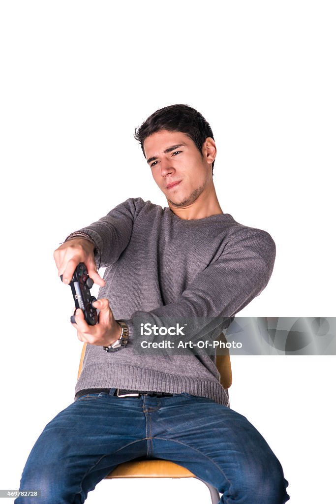 Attractive young man using joystick or joypad for videogames Attractive young man using joystick or joypad for videogames, isolated on white, sitting on stool 2015 Stock Photo