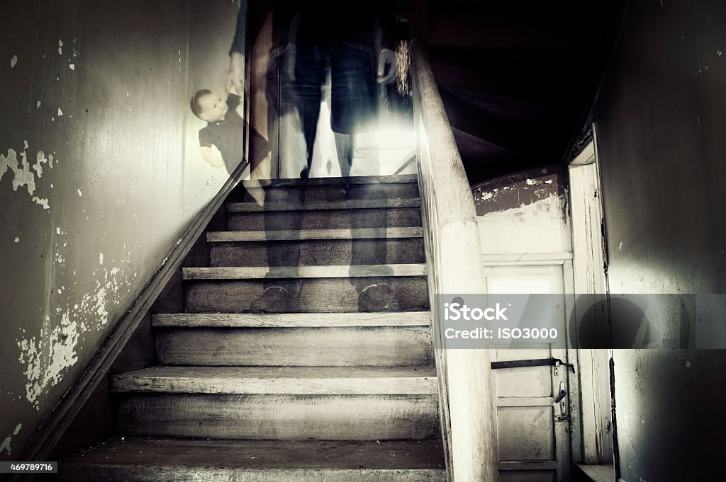 Ghostly figure in a hounted house Ghostly figure standing on stairs inside a hounted house holding doll Ghost Stock Photo