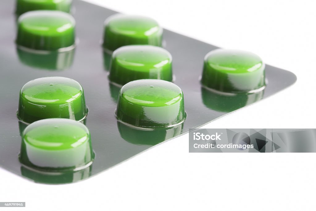Green pills in a blister pack on white Antibiotic Stock Photo