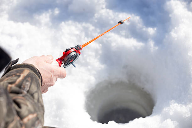 istock hand holding small red bait for winter fishing 469792952