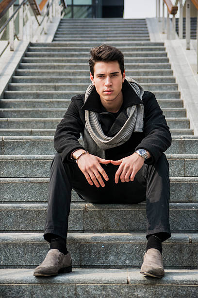 istock Trendy handsome young man sitting on a long staircase outside 469793018