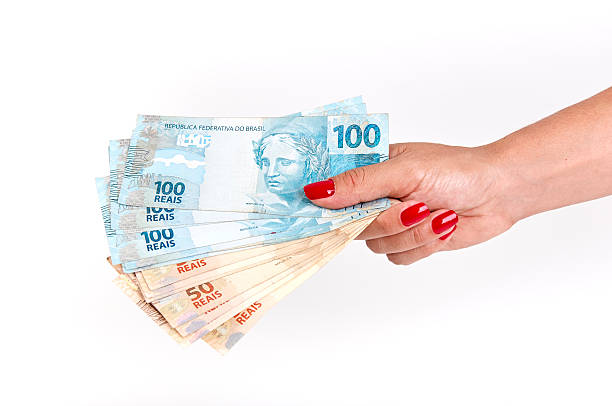 Woman's hand and Brazilian money stock photo