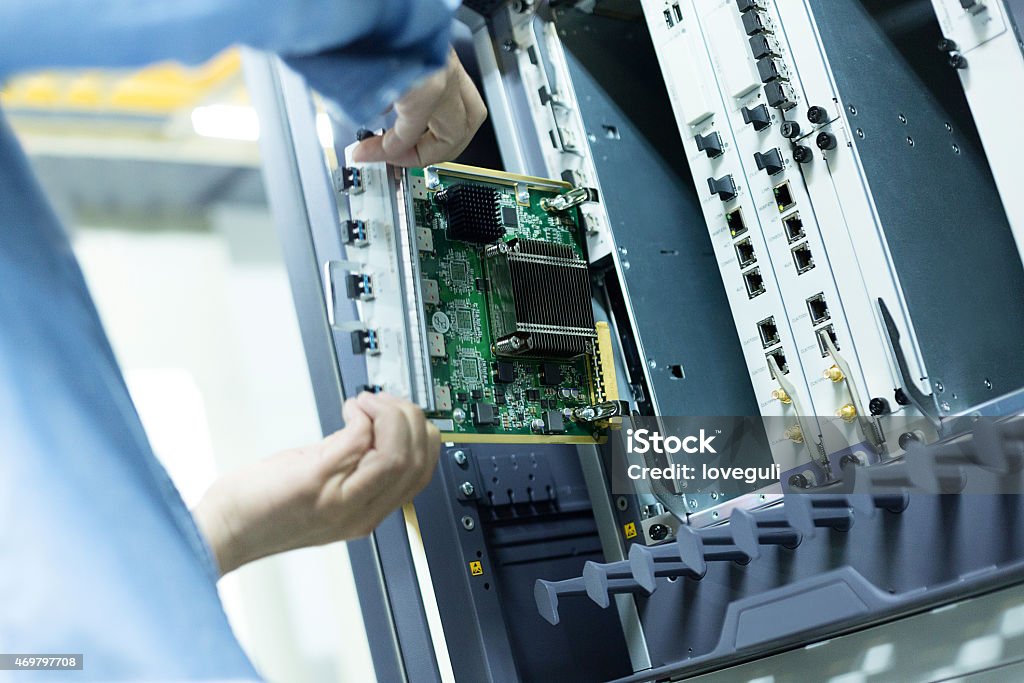 telecommunication engineer install hardware to the data server Installing Stock Photo