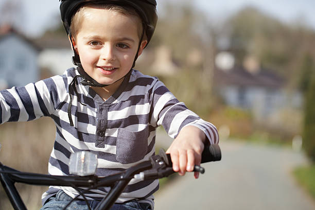 istock Smiling boy riding a bike with a blurred background 469799352