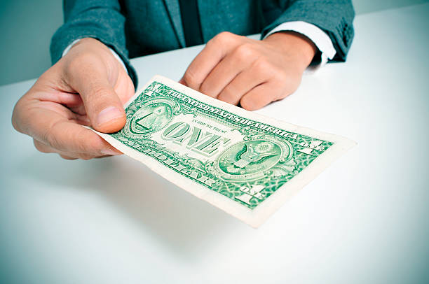 istock man in suit offering a one US dollar bill 469801447