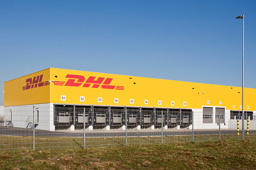 Kelsterbach, Germany - October 2, 2011: Facade and loading bays of DHL distribution hub at Moenchhof area in Kelsterbach, Germany. Moenchhof area is a newly developed industry park nearby the Frankfurt airport. DHL is part of Deutsche Post providing international mail services. Operating under the name Deutsche Post DHL it is the world's largest logistics group.