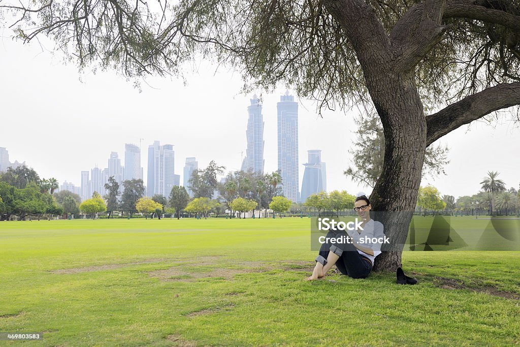 Young woman reading a book in the park Young student woman reading a book and study in the park Adult Stock Photo