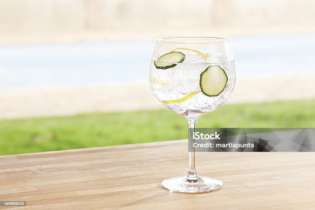 Cucumber gin and tonic cocktail by a pool outdoors Cucumber gin and tonic cocktail on poolside bar Gin Stock Photo