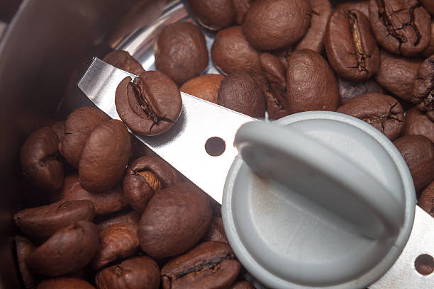 istock Macro electric coffee-mill machine with roasted coffee beans isolate background 469808889