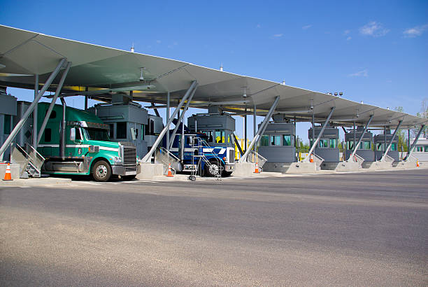 Semi trucks pay at tollbooth at Canadian border stock photo