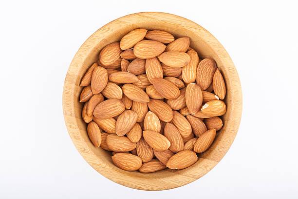 istock Almond nuts in wooden bowl isolated on white background 469810021