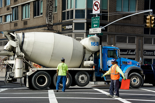 New York City, USA - October 28, 2014: Construction workers guide a cement truck arriving at a High-rise residential building under construction in Manhattan’s West Side.