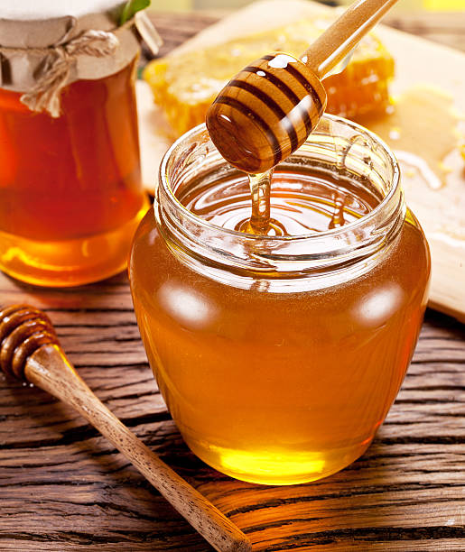 istock Honey flowing into glass can. 469811372