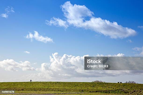 Woman Cyclist With Blue Sky Breaking Through White Cloud Background Stock Photo - Download Image Now