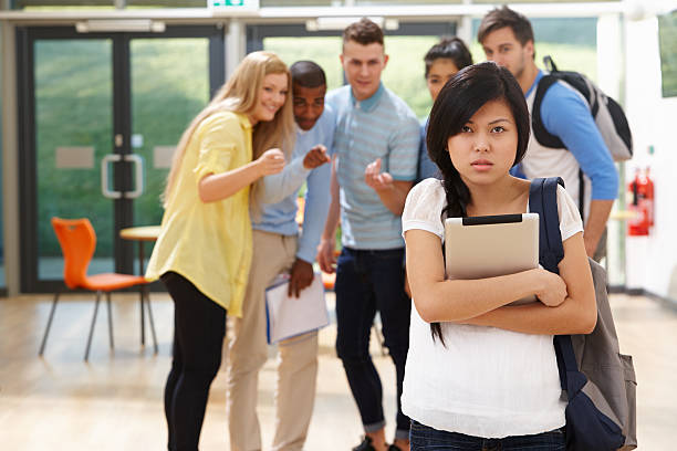 High school students bully a nearby female student stock photo