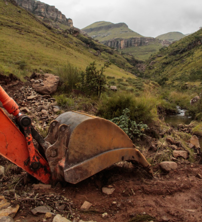 Excavating in the Lesotho mountains with a red excavator