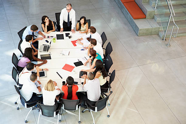 istock Businessman Addressing Meeting Around Boardroom Table 469819673