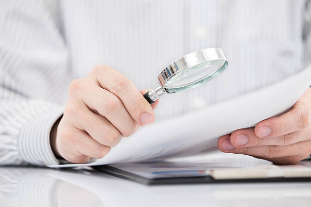 istock Businessman looking through a magnifying glass 469819815