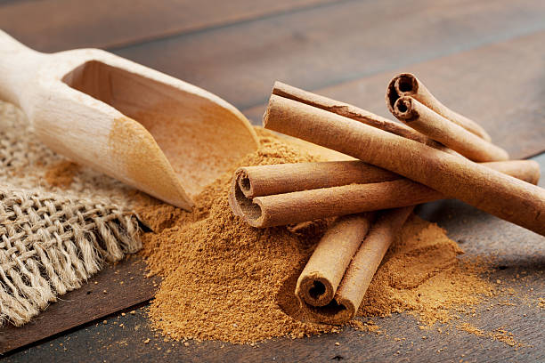 Cinnamon sticks and powder in wooden scoop stock photo
