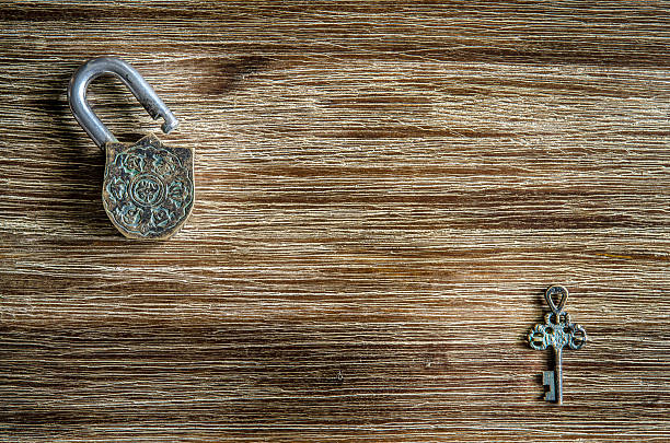 istock Open vintage padlock and key on a wooden texture 469823863