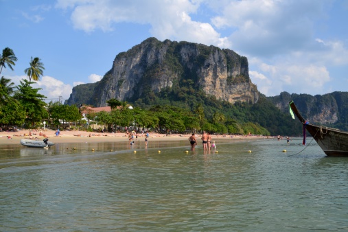 Ao Nang, Thailand - January 16, 2014: beach relax at Ao Nang in Krabi province. Tourists sunbathing and swimming in the Andaman sea under the huge limestone rocks.