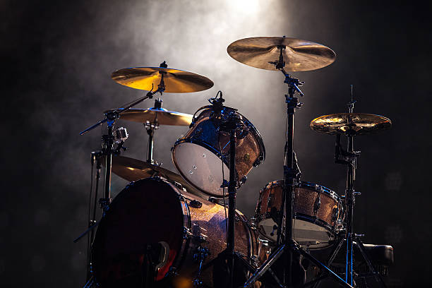 Spotlighted rock and roll drum set on gray background Concert drummer stock pictures, royalty-free photos & images