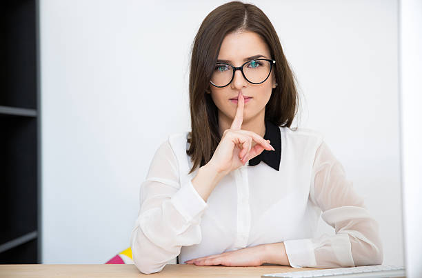 istock businesswoman with finger over lips 469825936