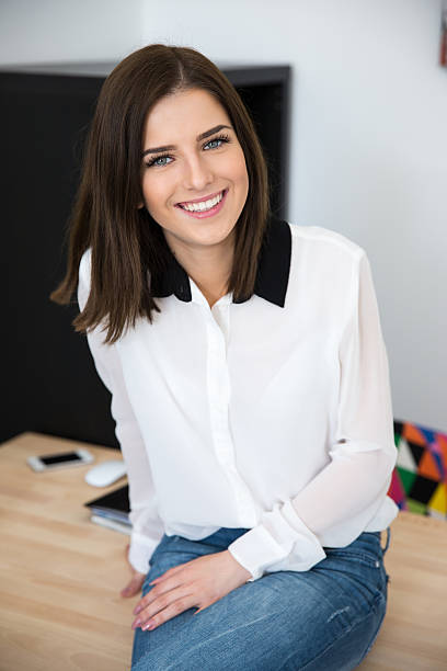 istock businesswoman sitting on the table in office 469826402