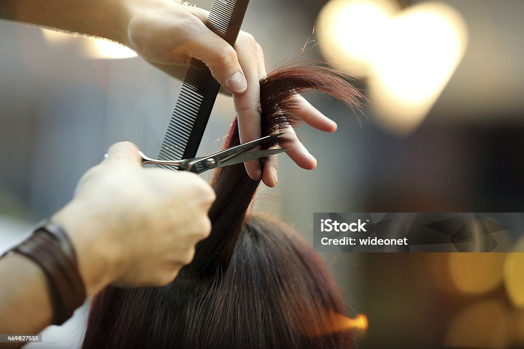 Barber cutting hair Hairdresser trimming blond hair with scissors Hair Salon Stock Photo