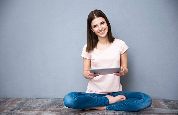 istock woman sitting on the floor with tablet computer 469830194
