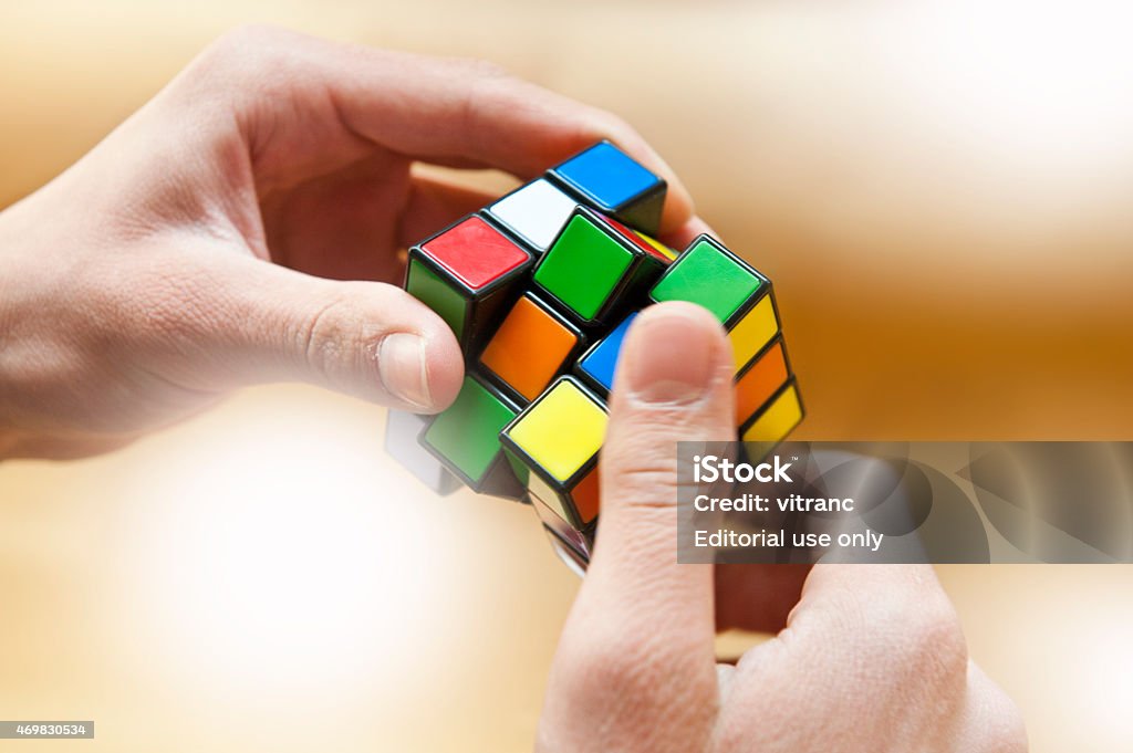 Hands playing a cube game Kranj, Slovenia - April 11, 2015: Hands playing a Rubik's Cube game.Rubik's Cube is a 3D mechanical puzzle invented in 1974 by Hungarian sculptor and professor of architecture Ernő Rubik Puzzle Cube Stock Photo