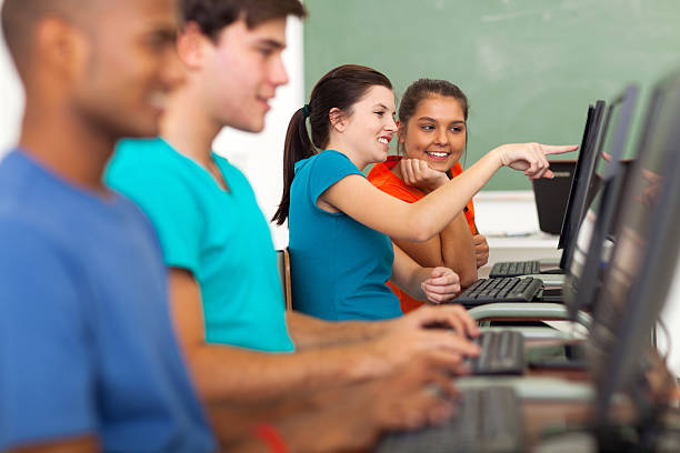 istock teenage girl helping a classmate with computer 469836629