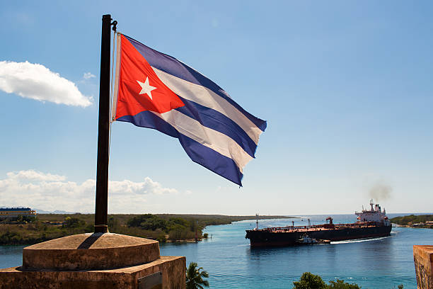 Cuba flag waving on the wind with a big boat in background