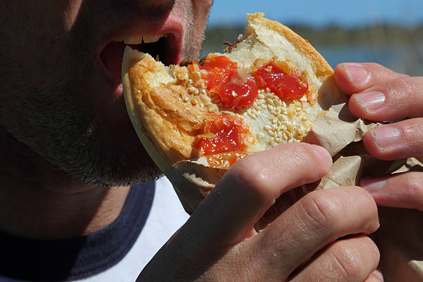 Eating A Meat Pie Stuffing his face with a meat pie. meat pie stock pictures, royalty-free photos & images