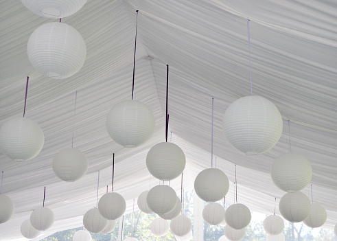 Closeup of paper lanterns in a tent for a wedding reception.  