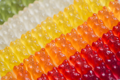 Rows of gummy bears. Green,white,yellow, orange, red, dark red