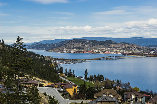 A view of the bridge over Okanagan Lake between West Kelowna and Kelowna Brititsh Columbia Canada with a view of the Kelowna skyline and mountains in the backgound