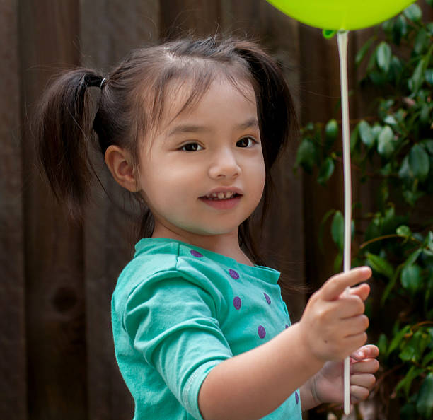 istock toddler plays with her balloon 469859925