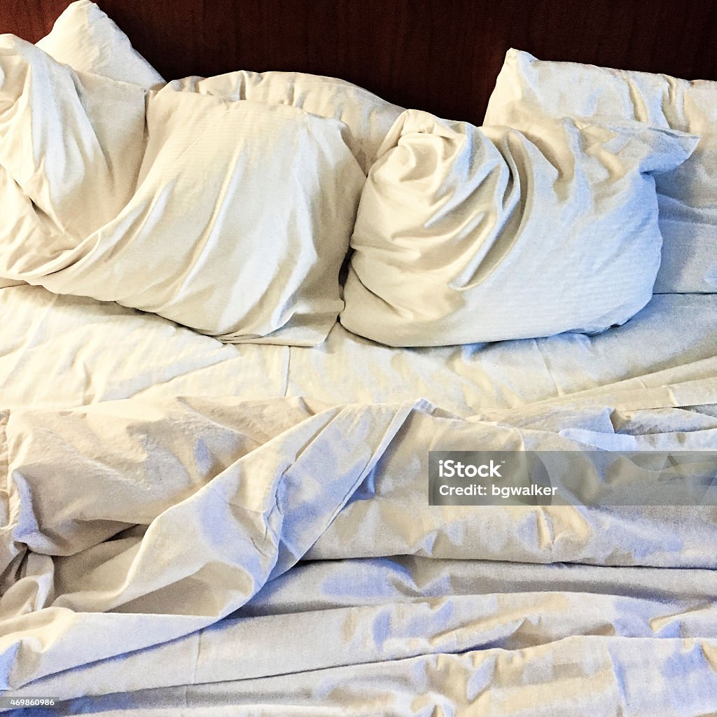 Bed Sheets and Pillows Rumpled and Texture Added Hotel bed sheets and pillows messy and rumpled.   Texture added.   Photographed with an iPhone 6. Dirty Stock Photo