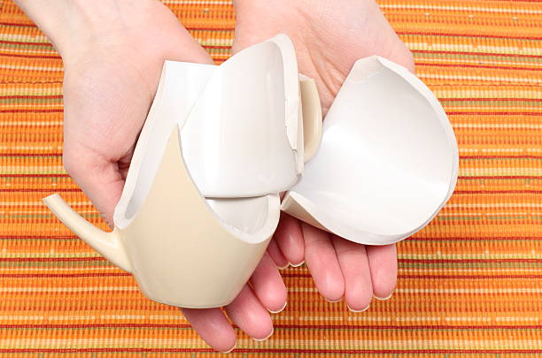 istock Broken cup lying on hand of woman 469863061