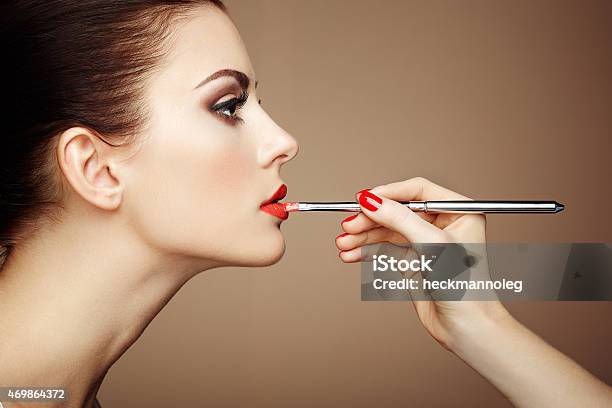 Closeup Of Makeup Artist Hand Applying Lipstick On Model Stock Photo - Download Image Now