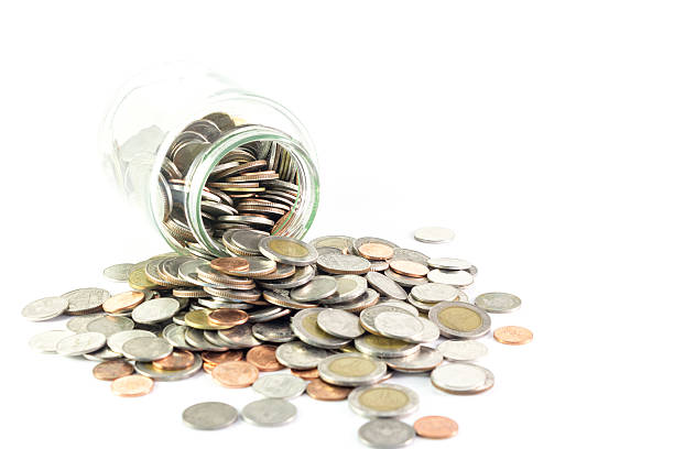 istock Isolated coins spilling from a money jar 469868982